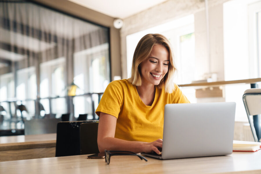 Women working on laptop in a bright office.
